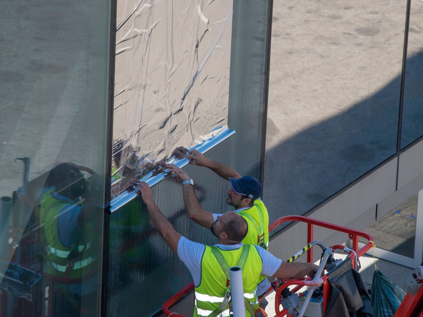 Installation de film solaire en hauteur sur vitrages depuis nacelle – ADPOSE